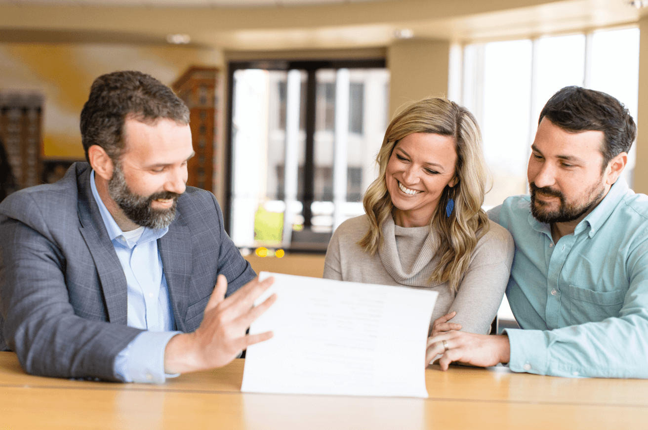 Clarke at desk providing advice to young couple